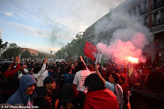 A festa da Copa do Mundo acontece nas ruas da Holanda às 6h… mas os torcedores do Marrocos comemoram com sinalizadores enquanto a tropa de choque holandesa reprime as prisões matinais depois de ver seu país eliminado nos pênaltis.